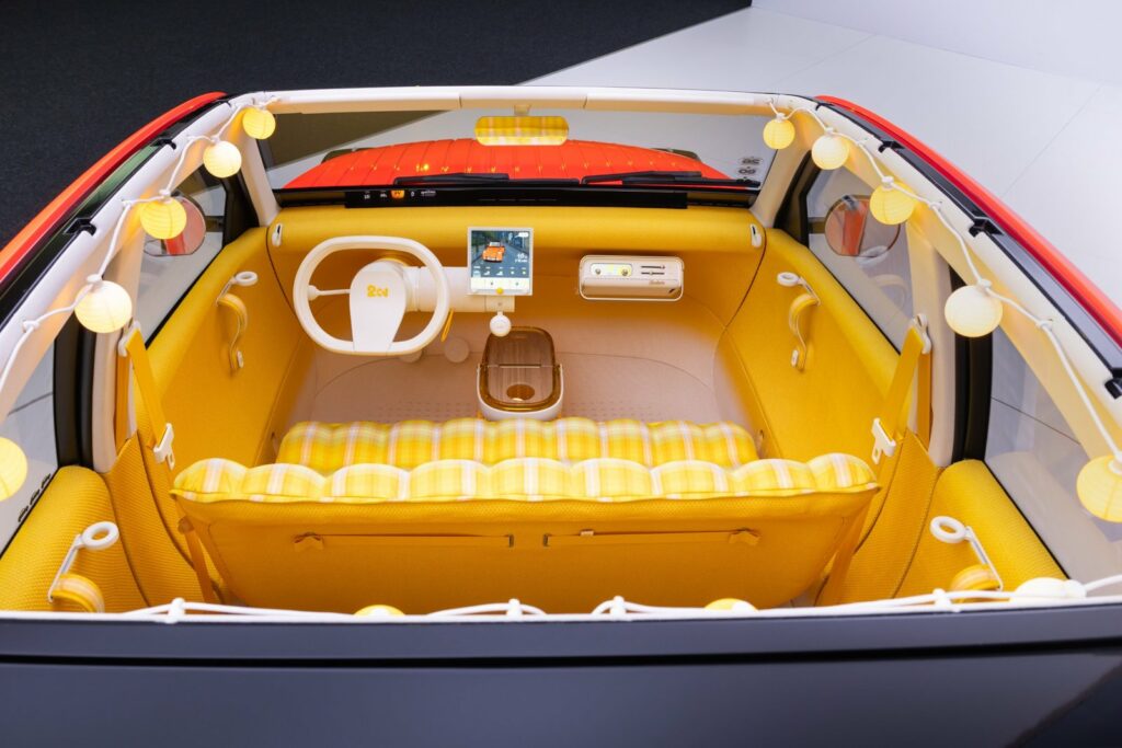 Intérieur jaune de la Citroën 2 CV Concept avec banquette à carreaux et guirlande lumineuse